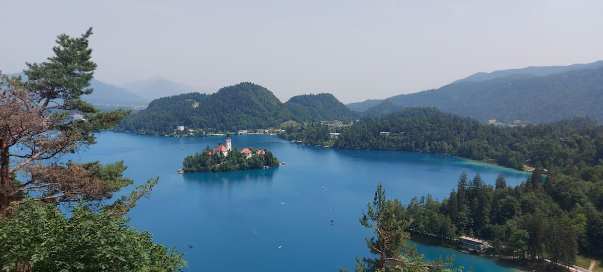 Lake Bled island church in blue water surrounded by forested hills in Slovenia