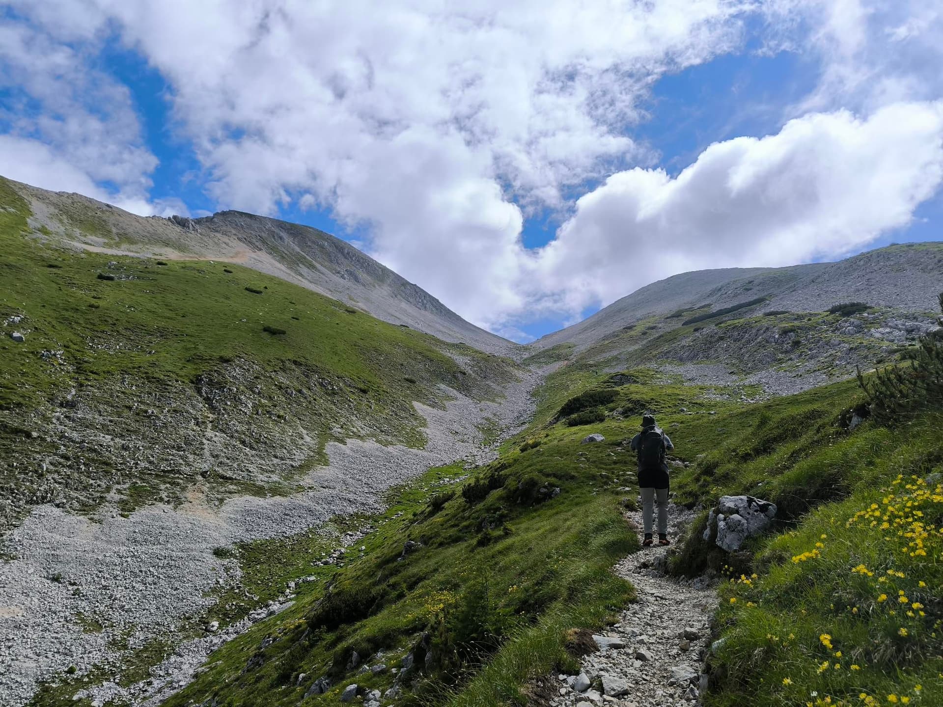 Hiker with a backpack on a rocky trail in the Karawanks mountain range.