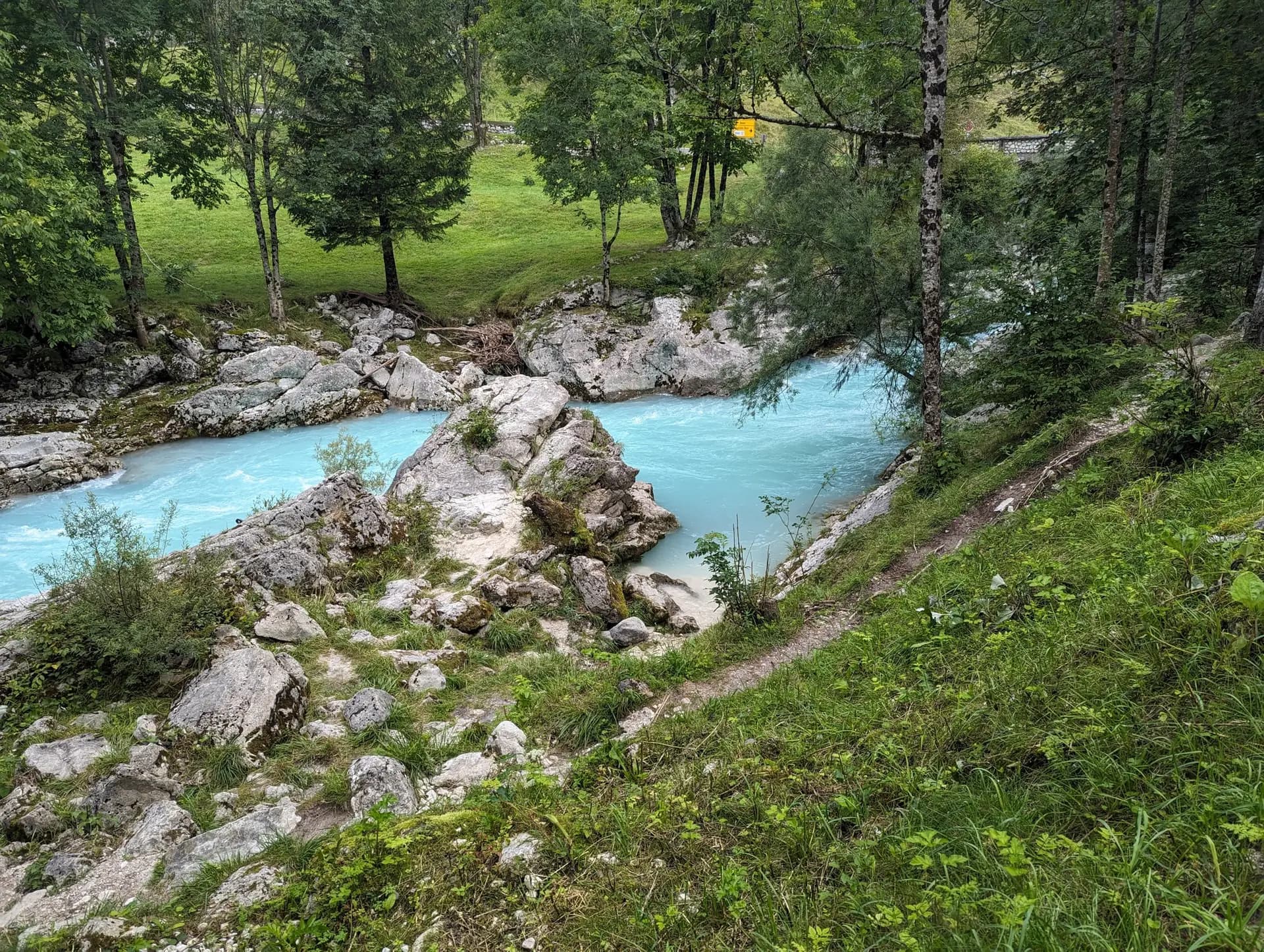 Turquoise river flowing through rocky terrain in the Julian Alps surrounded by forest.