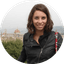 Smiling woman in a black jacket with the Florence Cathedral and city skyline in the background.