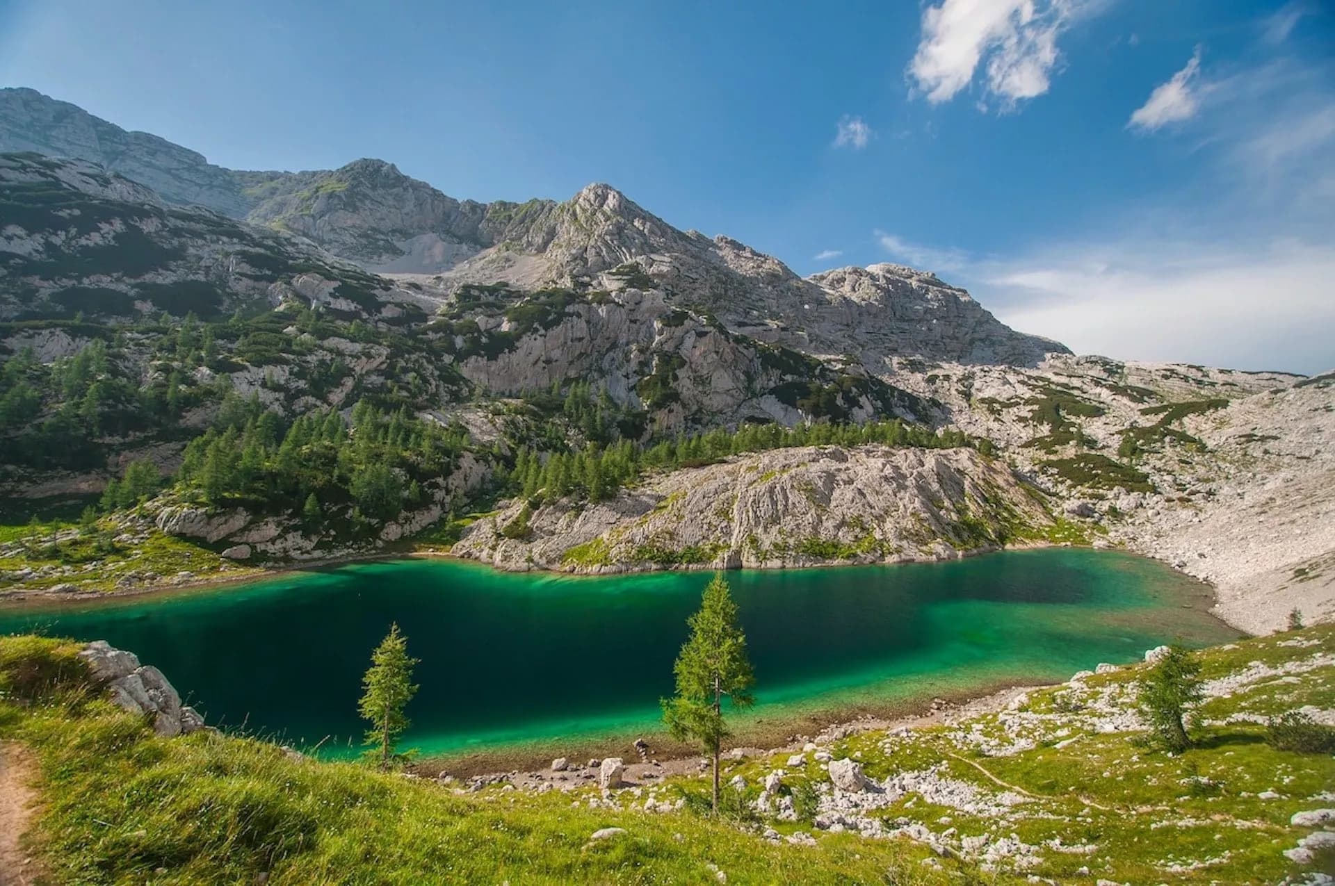 Kidney Lake with emerald water surrounded by rocky mountains and green alpine terrain