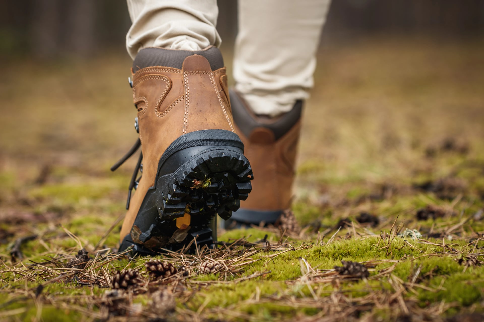 Toerist met wandelschoenen die op een voetpad in het bos loopt. Trekkingpad in het bos. Waterdichte leren enkelboot