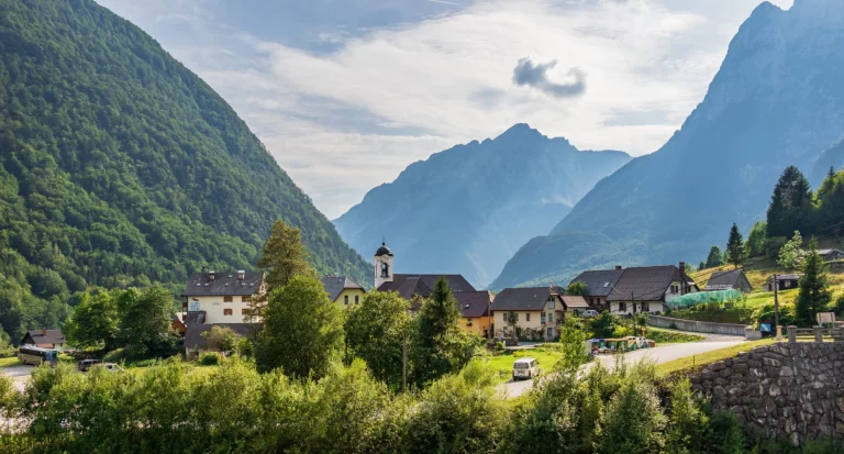 Panorama with buildings, main Road and Parish Church inside Mountain Landscape of Village Log pod Mangartom. Bovec, Slovenia, Europe.